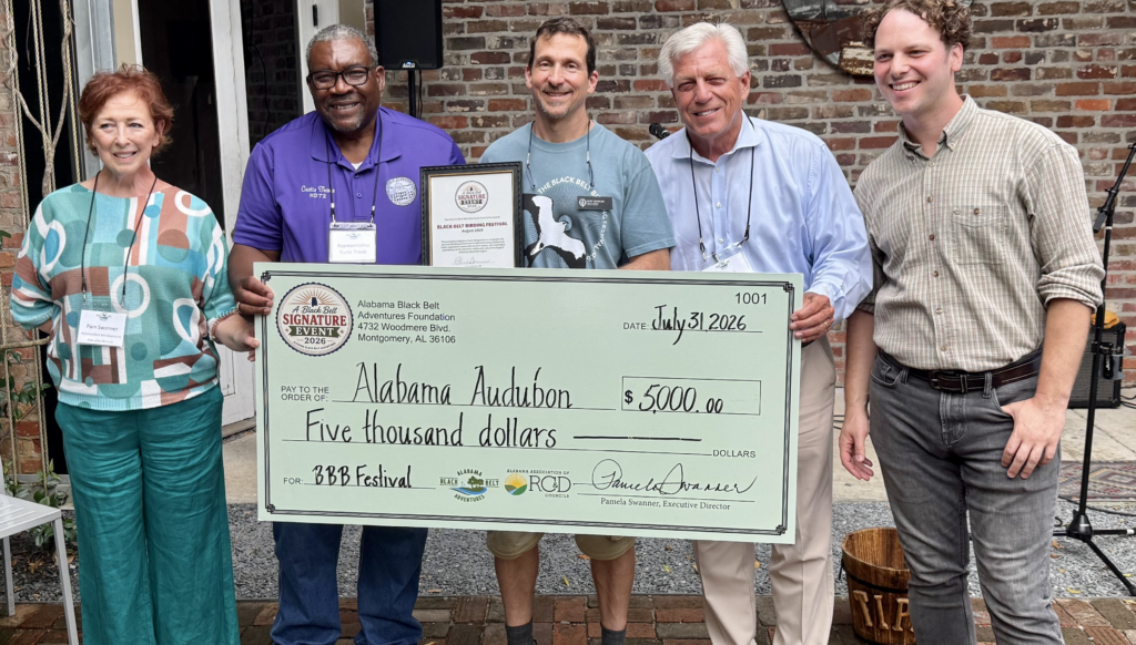 Alabama Black Belt Adventures Association Executive Director **Pam Swanner** presents the **$5,000 grant check** to Alabama Audubon to support the Alabama Black Belt Birding Festival's continued growth and future programming. Pictured, from left, are Swanner, State Rep. **Curtis Travis**, Alabama Audubon executive director **Dr. R. Scot Duncan**, State Sen. **Gerald Allen** and **Tim Higgins**, coordinator of the Black Belt Birding Festival. *(Photo courtesy of the Alabama Black Belt Adventures Association)*